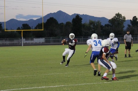 Quarterback Jalil Mitchell (5) throwing over a defender on the run.