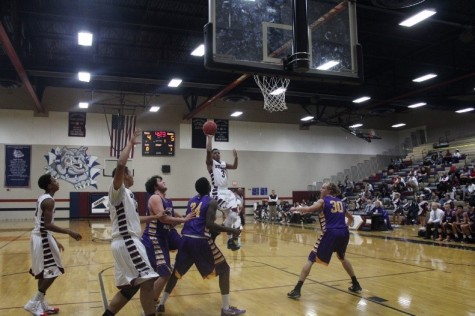 Donta A. (#3) shooting a layup over three Mustang defenders. 