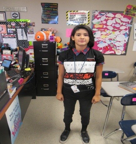 SLHS Sophomore Anabelle B. is wearing a black Twenty One Pilots band t-shirt with a plaid red and blue shirt with the collar over her shirt and the sleeves folded over the black shirt. She is also wearing black jeans with black Nike’s to bring the outfit together.